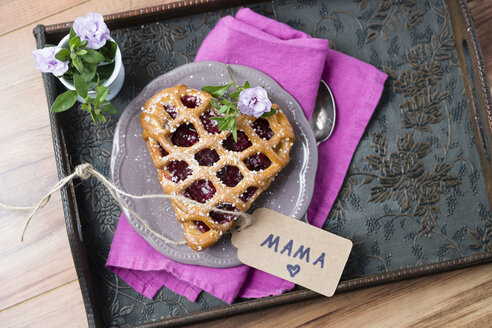 Herzförmige Kirschtorte mit Namensschild und Blumen auf dem Tablett - MYF001478