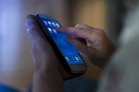 Hände des Seniors berühren das Smartphone, lizenzfreies Stockfoto