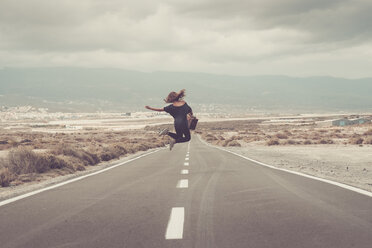 Young woman jumping for joy on a road - SIPF000485