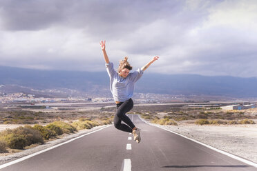 Young woman jumping for joy on a road - SIPF000491