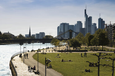 Germany, Hesse, Frankfurt, People at River Main with skyline in background - FCF000943