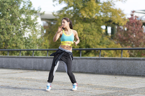 Junge Frau macht Tai Chi im Freien, lizenzfreies Stockfoto