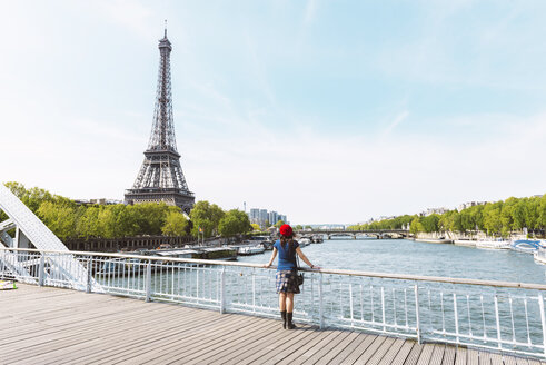 Frankreich, Paris, Rückenansicht einer Frau mit roter Baskenmütze mit Blick auf den Eiffelturm - GEMF000894