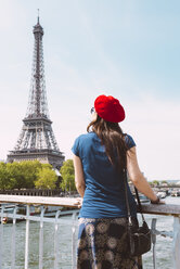 Frankreich, Paris, Rückenansicht einer Frau mit roter Baskenmütze mit Blick auf den Eiffelturm - GEMF000896