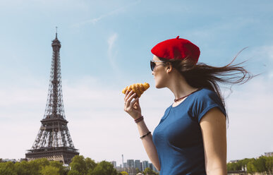 Frankreich, Paris, Frau mit Croissant und Blick auf den Eiffelturm - GEMF000901