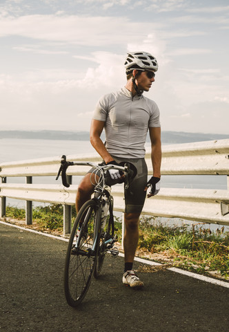 Radsportler mit seinem Rennrad am Abend, lizenzfreies Stockfoto