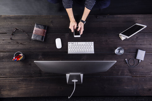 Mann bei der Arbeit am Schreibtisch mit Computer und verschiedenen digitalen Gadgets - HAPF000340