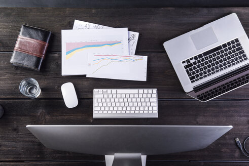 Desk with computers and charts, overhead view - HAPF000350