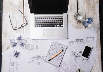 Schreibtisch eines Architekten mit Laptop und Skizzen - HAPF000374