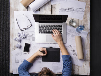 Architect working at desk with laptop, making sketches - HAPF000377