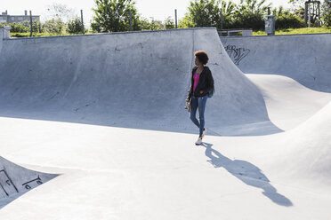 Junge Frau geht im Skatepark - UUF007257