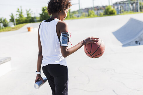 Junge Frau mit Basketball im Skatepark - UUF007264