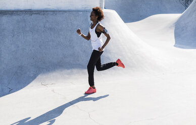 Young woman running in skatepark - UUF007272