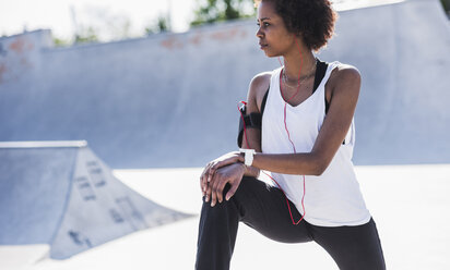 Junge Frau beim Stretching im Skatepark - UUF007282