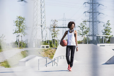 Junge Frau mit Basketball im Skatepark - UUF007284