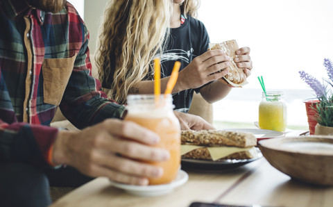 Ehepaar frühstückt in einem Café und trinkt Bio-Säfte, lizenzfreies Stockfoto