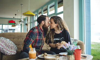 Couple kissing at breakfast in cafe - DAPF000099
