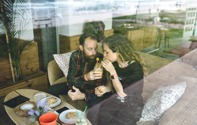 Couple having breakfast in cafe, drinking organic juices - DAPF000100