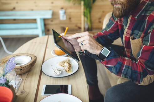 Man sitting in cafe, using digital tablet - DAPF000101