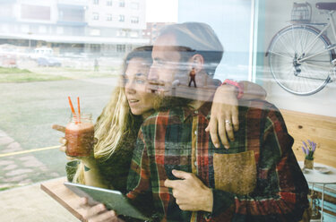 Ehepaar frühstückt in einem Café und benutzt ein digitales Tablet - DAPF000109