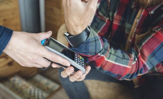 Mann bezahlt mit Smartwatch im Café - DAPF000116