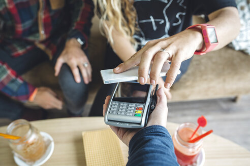 Woman paying with smart phone in cafe - DAPF000117