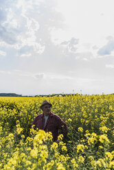 Farmer in blossoming rape field - UUF007324