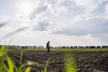 Farmer standing in a field - UUF007341