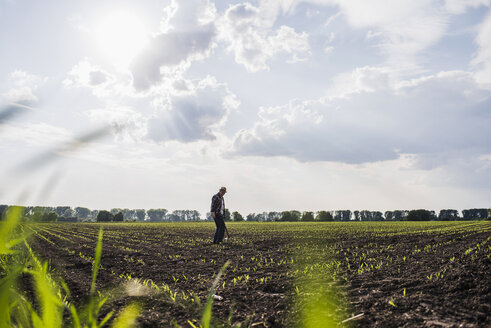 Landwirt auf einem Feld - UUF007341