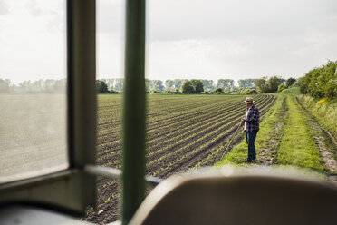 Landwirt steht auf einem Feld - UUF007350