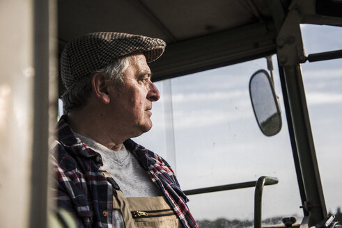 Porträt eines Landwirts auf einem Traktor - UUF007362