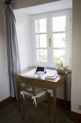 Digitales Tablet, Bücher und Kaffeetasse auf dem Schreibtisch in einem Landhaus - RIBF000402
