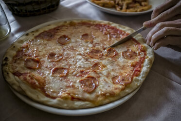 Frau beim Pizzaschneiden - RIBF000420