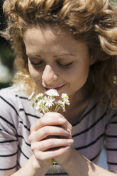 Portrait of woman smelling daisies - GIOF001045