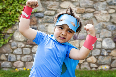 Little big hero with a mask against a stone wall stock photo