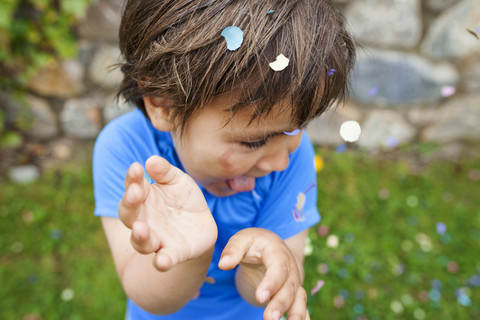 Lttle boy playing with confetti stock photo