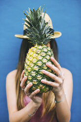 Young woman holding pineapple in front of her face - EBSF001378