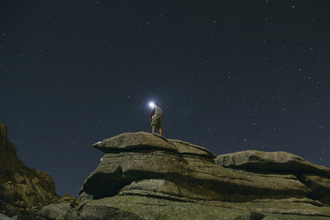 Spain, man with headlamp under a starry sky on a rock in La Pedriza stock photo