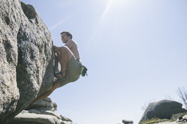 Spanien, Kletterer ohne Hemd klettert auf einen Felsblock in La Pedriza - ABZF000546