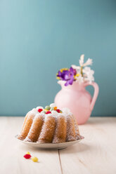 Ringkuchen mit Ostereiern und Blumenstrauß im Hintergrund - MYF001486