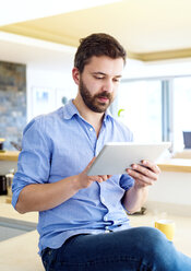 Mann arbeitet in der Küche mit digitalem Tablet - HAPF000387
