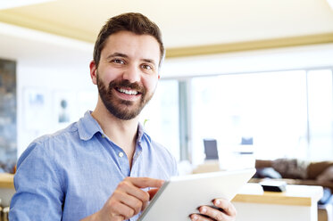 Man working in kitchen using digital tablet - HAPF000388