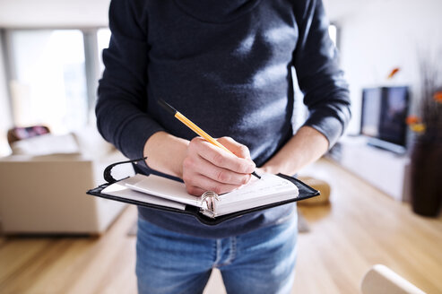 Man writing into his personal planer - HAPF000410