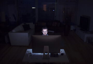 Mann, der nachts arbeitet und einen Computer benutzt - HAPF000432