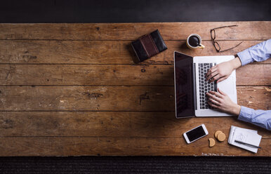 Man working with laptop at his desk - HAPF000443