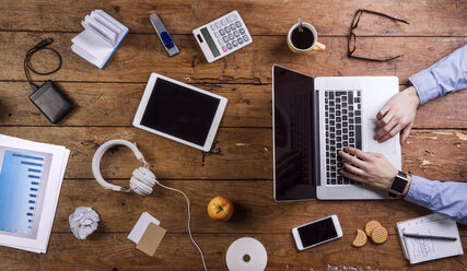 Man working with laptop at his desk - HAPF000452