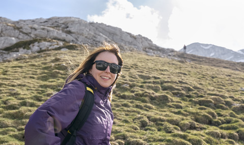 Spanien, Asturien, Somiedo, lächelnde Frau beim Wandern in den Bergen, lizenzfreies Stockfoto