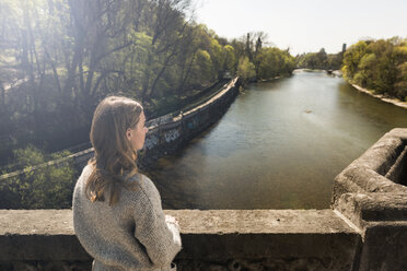 Junge Frau auf Brücke mit Blick auf den Fluss - KAF000139