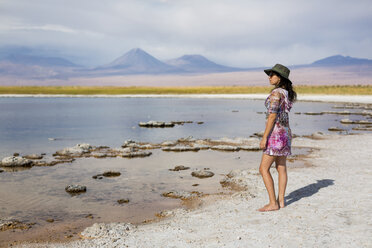 Chile, San Pedro de Atacama, Frau steht in der Wüste am Seeufer - MAUF000605