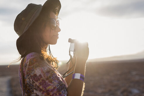 Chile, San Pedro de Atacama, Frau mit Kamera in der Wüste im Gegenlicht - MAUF000612